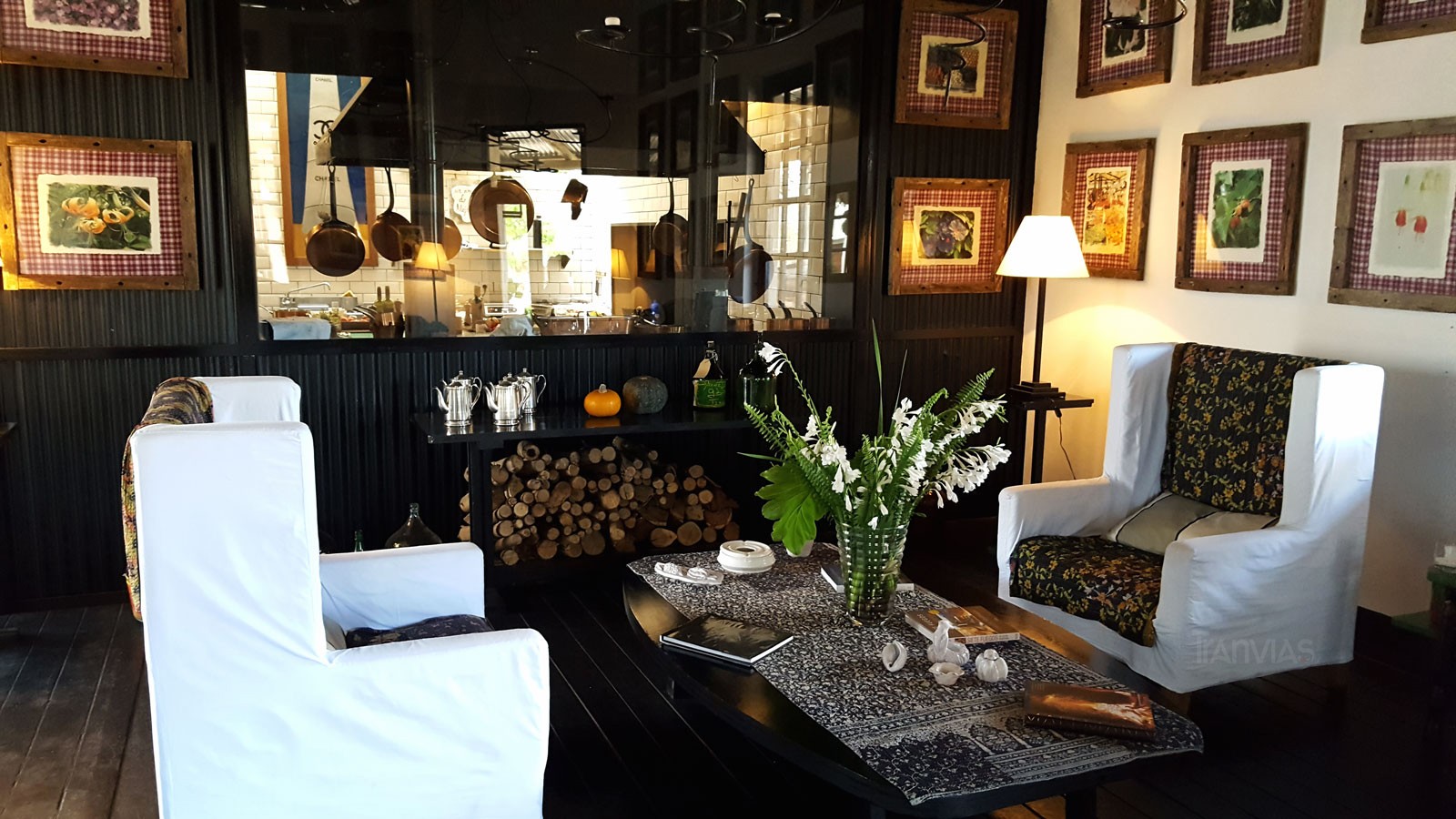 el salón, living y detrás un ventanal que muestra el corazón del lugar, la cocina