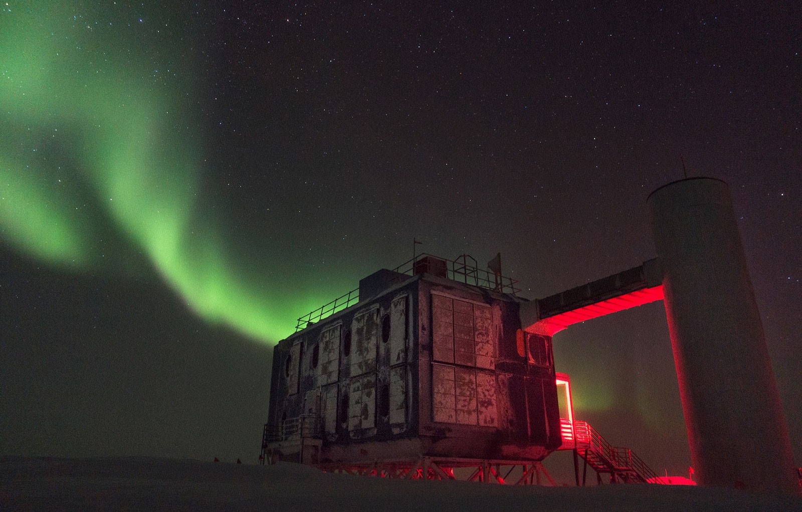 Las auroras suelen ser un paisaje cotidiano en el observatorio de neutrinos IceCube en la Antártida, donde en 1 km cúbico de hielo se detectan las partículas subatómicas que atraviesan la atmósfera. Una composición en alto contraste, entre el cielo y la tierra, el frío y algún color que intenta ser cálido. Foto: M. Wolf, IceCube/NSF. 2017